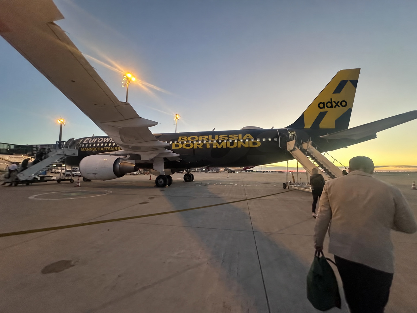 Boarding zum Strategie-Workshop: Eurowings-Maschine im BVB-Design mit adxo-Logo am Leitwerk, Abendlicht