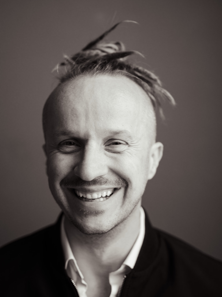 Sepia-Porträt: Sebastian Winkler lacht, dunkle Jacke über weißem Hemd
